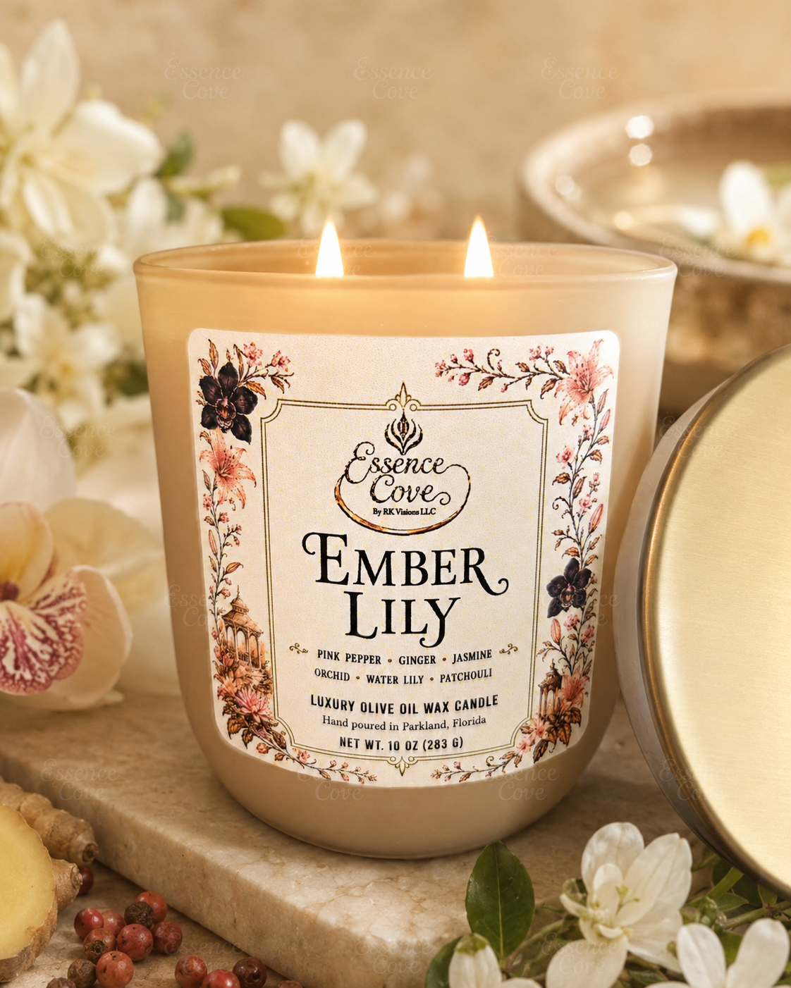 Essence Cove Ember Lily 10 oz luxury olive oil wax candle with double cotton wicks and gold lid lit on a stone surface surrounded by lilies and orchids.