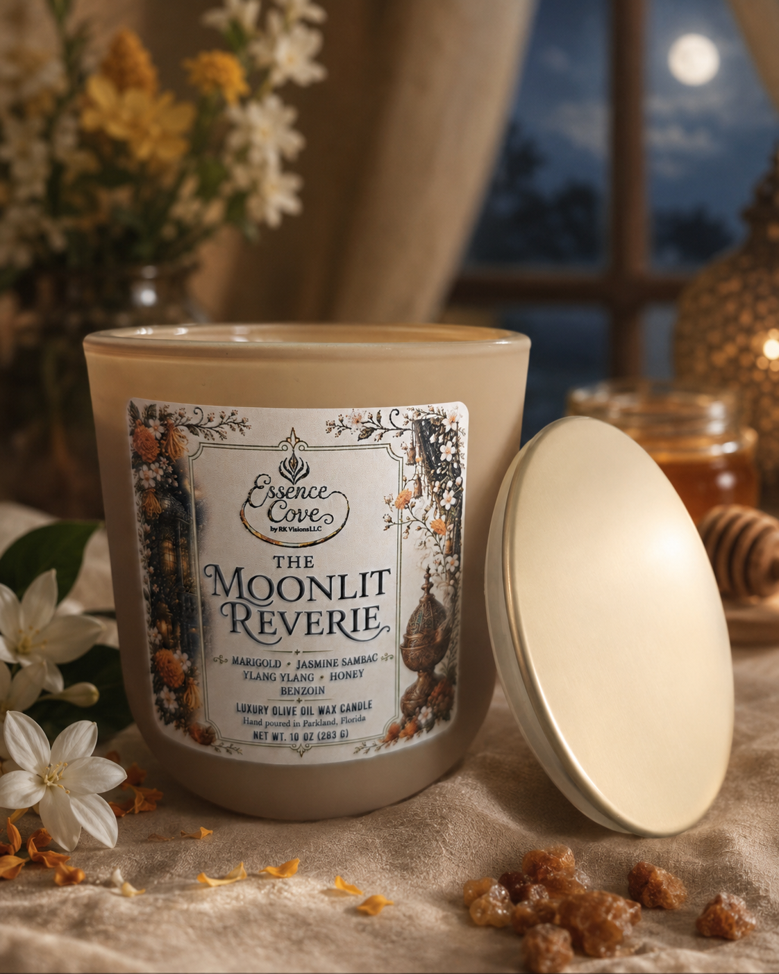 The Moonlit Reverie luxury 10 oz olive oil wax candle with dual lit wicks in a sand-colored matte glass jar, surrounded by raw honey, Jasmine and marigolds by Essence Cove.
