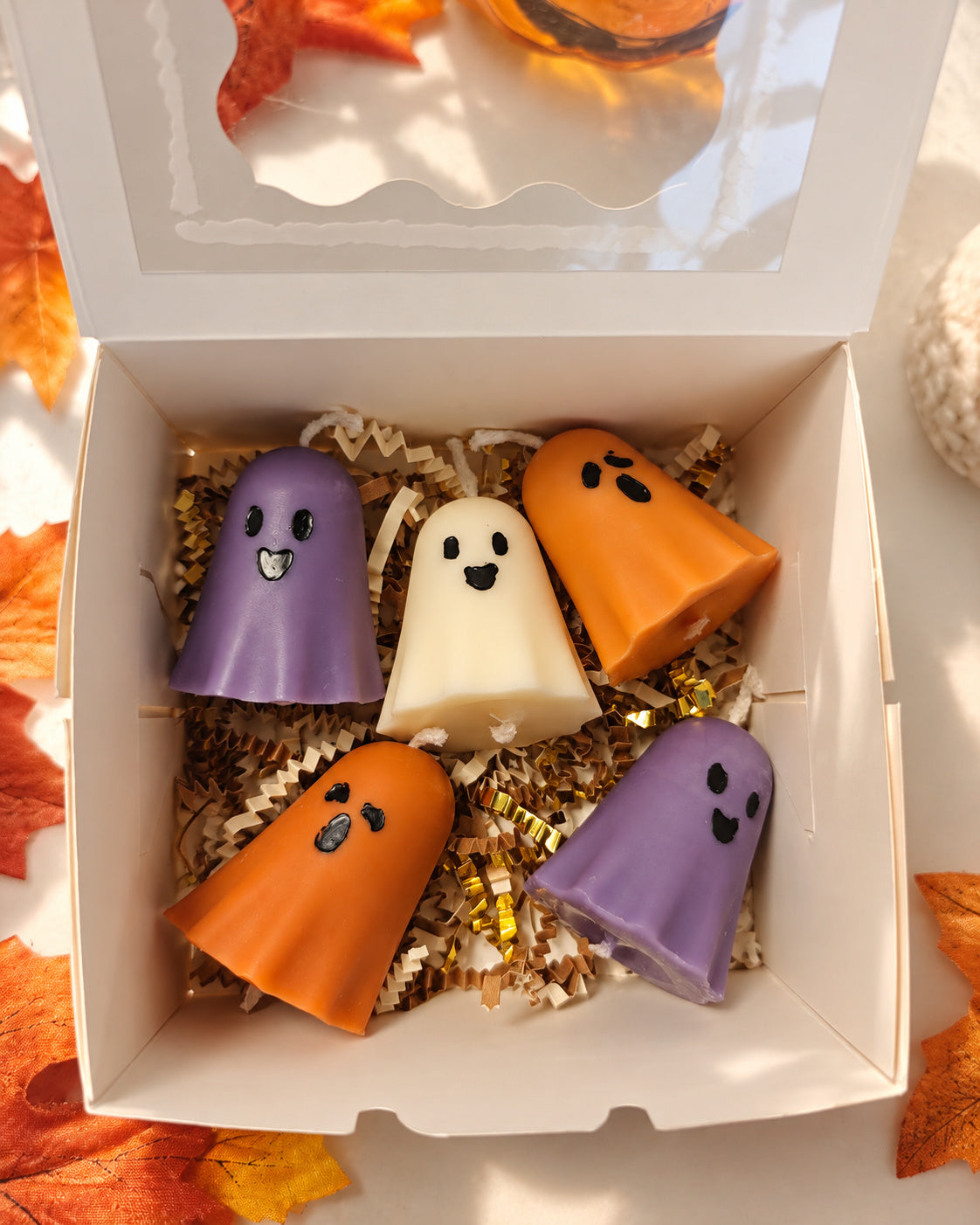 Open Ghost Town gift box with five orange, purple and ivory mini ghost pillar candles
